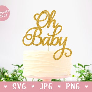 Może przedstawiać: Złoty topper na tort z błyszczącymi drobinkami z napisem "Oh Baby" w ozdobnym, pochylonym piśmie. Topper znajduje się na białym torcie.