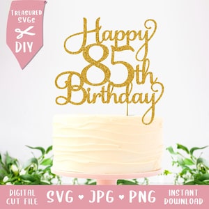 Peut inclure: Un gâteau blanc givré avec un cake topper doré à paillettes « Joyeux 85e anniversaire ». Le gâteau repose sur un présentoir à gâteau rose. L'image comprend également le texte « Treasured SVGs DIY » et « DIGITAL CUT FILE SVG JPG PNG INSTANT DOWNLOAD ».