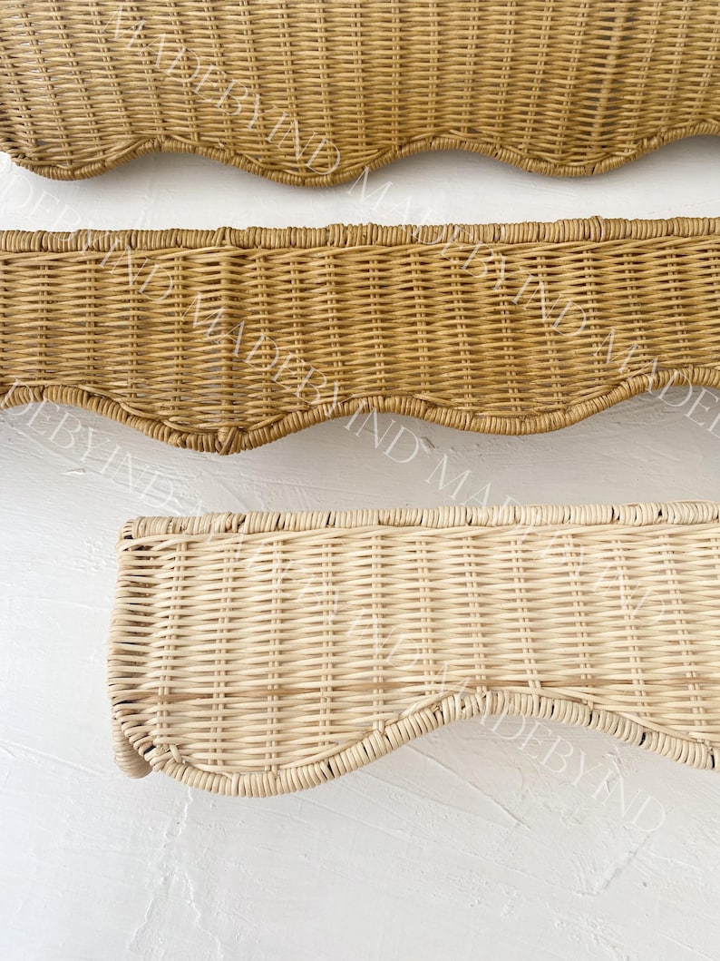 K&ouml;nnte beinhalten: Drei rechteckige Wandregale aus geflochtenem Rattan mit gewelltem Rand. Die oberen zwei Regale haben einen mittelbraunen Farbton, w&auml;hrend das untere Regal eine hellere, nat&uuml;rliche Cremefarbe aufweist. Jedes Regal zeigt ein enges Webmuster.