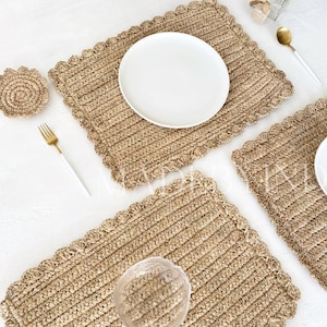 Könnte beinhalten: Drei natürliche gewebte Tischsets mit gewellten Kanten. Die Tischsets sind aus einem hellbraunen Material gefertigt und haben eine subtile Textur. Ein Tischset hat einen weißen Teller darauf, und ein anderes hat eine klare Glasschüssel darauf.