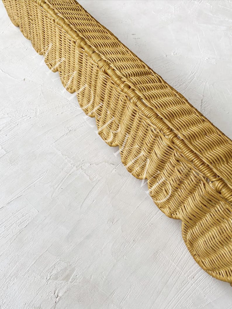 Puede incluir: Una bandeja rectangular larga de mimbre con un acabado natural en color marr&oacute;n claro y un dise&ntilde;o de borde festoneado decorativo a lo largo del lateral. La textura tejida es uniforme en toda la pieza, mostrando un patr&oacute;n de espiga detallado.
