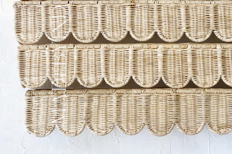 Puede incluir: Un tapiz de pared de mimbre tejido en color beige claro con tres paneles horizontales. Cada panel est&aacute; construido con un tejido de ca&ntilde;a vertical y rematado con un borde festoneado distintivo en la parte inferior, creando una apariencia texturizada.