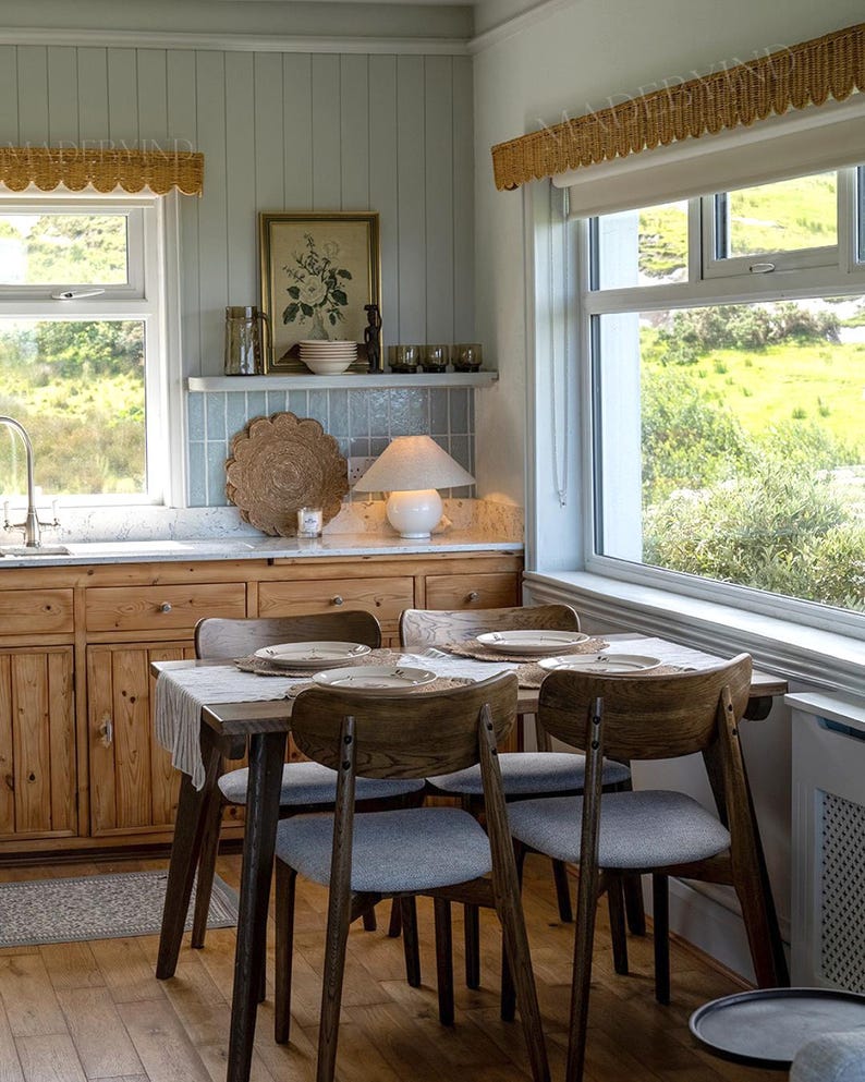Puede incluir: Un juego de comedor con una mesa rectangular de madera y cuatro sillas con estructura de madera oscura y asientos tapizados en gris claro. La mesa est&aacute; puesta con cuatro platos blancos, manteles individuales tejidos y un camino de mesa blanco.