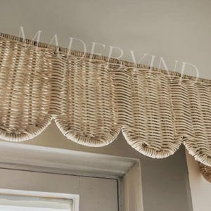 Puede incluir: Una cenefa de ventana de mimbre tejido en color beige claro con un borde inferior festoneado. La cenefa est&aacute; construida con material de ca&ntilde;a natural con un patr&oacute;n de tejido apretado y uniforme, dise&ntilde;ada para colgar horizontalmente.