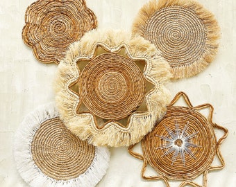 May include: Five woven wall decor pieces in various shapes and sizes. The pieces are made of natural materials and have a rustic, bohemian style. Some pieces have a fringe trim.