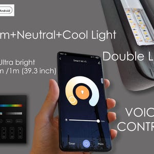 May include: Image of a smartphone displaying a smart lighting control interface. The screen shows a color wheel and brightness slider. Text on the image includes "Warm+Neutral+Cool Light", "Ultra bright 3200 Lm /1m (39.3 inch)", "Double LEDs", and "VOICE CONTROL".