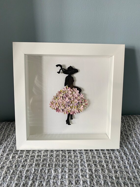 Lady silhouette with a flower skirt framed