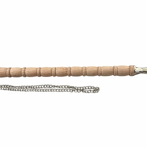 May include: A wooden pointer with a silver hand pointing to the right. The pointer has a chain attached to it.