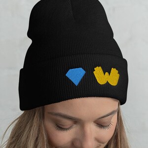 May include: Black beanie with a blue diamond and yellow hand symbols embroidered on the front.