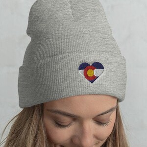 May include: A gray beanie with a heart-shaped Colorado flag embroidered on the front.