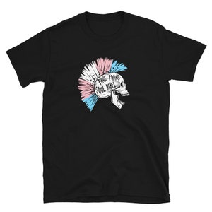 May include: Black t-shirt with a graphic of a skull with a mohawk made of pink, blue, and white stripes. The text "True Trans Soul Rebel" is written on the skull.