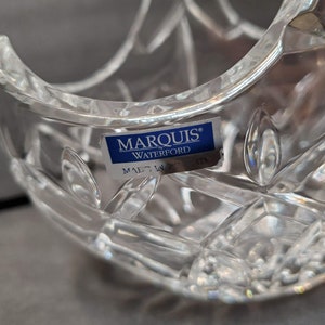 Pu&ograve; includere: Ciotola di cristallo trasparente con motivo a diamante e bordi curvi. Un'etichetta blu e bianca recita "MARQUIS by WATERFORD" e "MADE IN POLAND". La ciotola &egrave; progettata con una serie di linee intersecanti e forme a diamante.