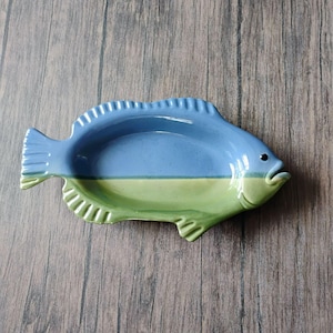 Puede incluir: Un juego de tres tazas de cerámica con un acabado mate moteado. Las tazas son de color crema, gris claro y gris oscuro. Cada taza tiene un diseño simple y minimalista.