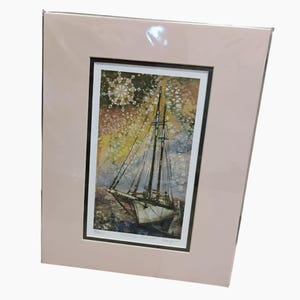 May include: A framed print of a sailboat with two masts, set against a colorful, abstract background. The print is matted in a light pink color and framed in black. The artwork depicts the sailboat on the water with a detailed design.