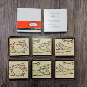 May include: Set of six square coasters with a vintage map design, featuring a black border and a glossy finish. The coasters are accompanied by two white boxes, one with a red stripe and the brand name "Pimpernel."