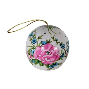 Może przedstawiać: Biała ceramiczna ozdoba w kształcie kuli z różową piwonią i niebieskim kwiatowym wzorem. Ozdoba ma złotą wstążkę do zawieszenia. Kula ma małe otwory i prawdopodobnie jest przedmiotem dekoracyjnym.