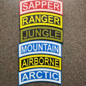 May include: Stacked patches with white text on colored backgrounds. The patches read: SAPPER, RANGER, JUNGLE, MOUNTAIN, AIRBORNE, and ARCTIC. Each patch has a black border and is set against a gray background.