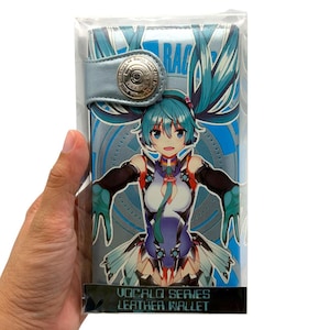 May include: A rectangular wallet featuring a blue and white anime character with teal twin-tails. The wallet has a metallic snap button closure and a blue background with circular patterns. The text VOCALO SERIES LEATHER WALLET is printed at the bottom.
