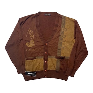 Puede incluir: Cárdigan marrón con cuello en V y cierre de botones. El suéter presenta un diseño temático de golf con la palabra "CLASSIC" y la palabra "GOLF" en la parte delantera. La etiqueta dice "WEIRDO".