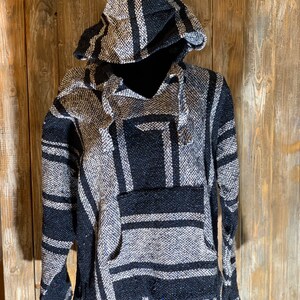 May include: Black and white striped hooded poncho with a pocket on the front.