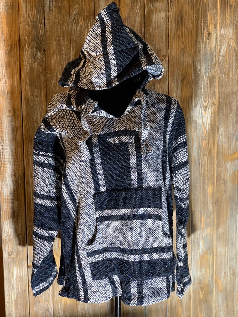 May include: Black and white striped hooded poncho with a pocket on the front.