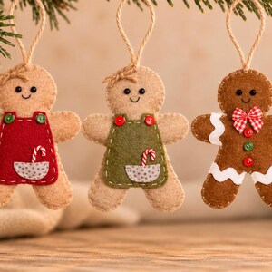 May include: Three felt gingerbread person ornaments hanging by twine loops. Two figures wear red and green aprons with small candy cane pockets. The third figure is brown with white icing trim, a red and white checkered bow, and red buttons.