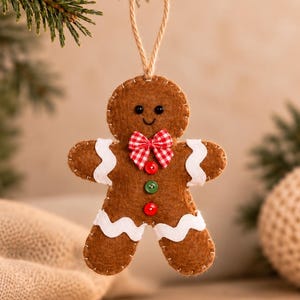 May include: A brown felt gingerbread man ornament featuring white rickrack trim on the arms and legs, a red and white checkered bow tie, and two small buttons in red and green. The figure has black bead eyes and a stitched smile.