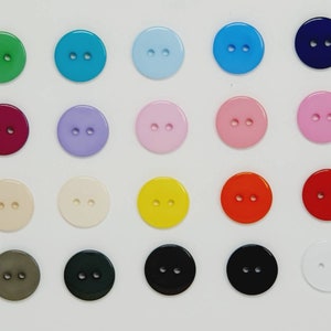 May include: Assortment of 20 round plastic buttons in various colours, including green, blue, purple, pink, yellow, red, white, black, and brown.