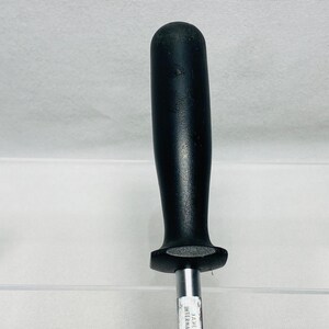 May include: A black handled steel knife sharpener. The handle is a solid black color and has a rounded top. The steel rod is silver and has text printed on it. The sharpener is designed for sharpening knives.