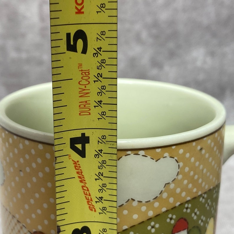 May include: A yellow and brown ceramic mug with a white cloud design and polka dots. The mug is 4 1/2 inches tall and has the words "Speed-Mark" and "Dura NY-Coat" printed on the side.