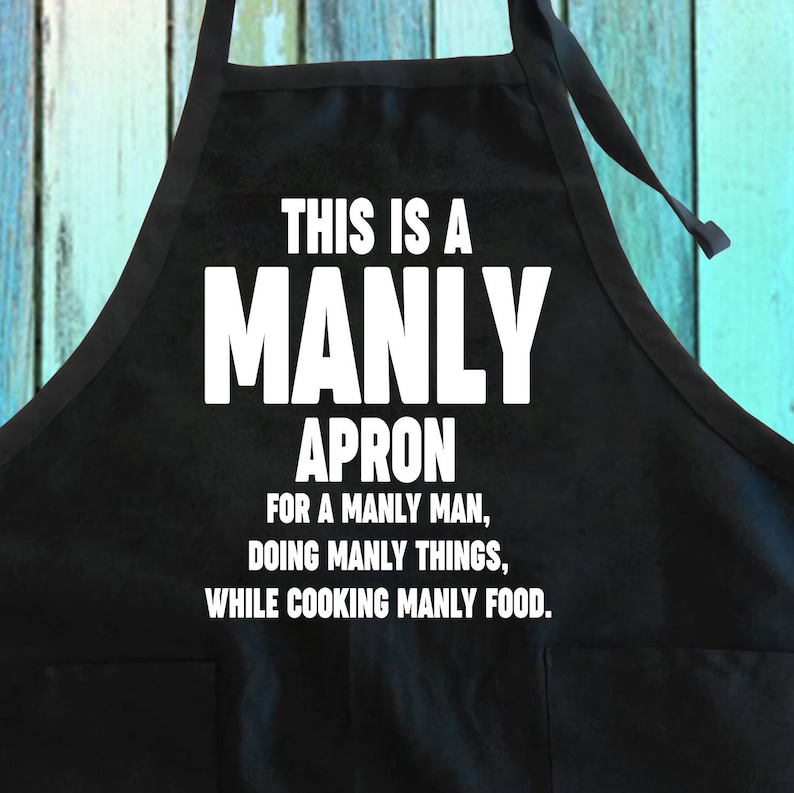 Puede incluir: Delantal negro con texto blanco que dice "Este es un delantal varonil para un hombre varonil, haciendo cosas varoniles, mientras cocina comida varonil."