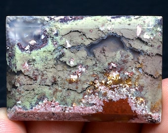May include: A rectangular slab of agate with a variety of colors and patterns, including green, brown, white, and pink. The agate has a smooth, polished surface.