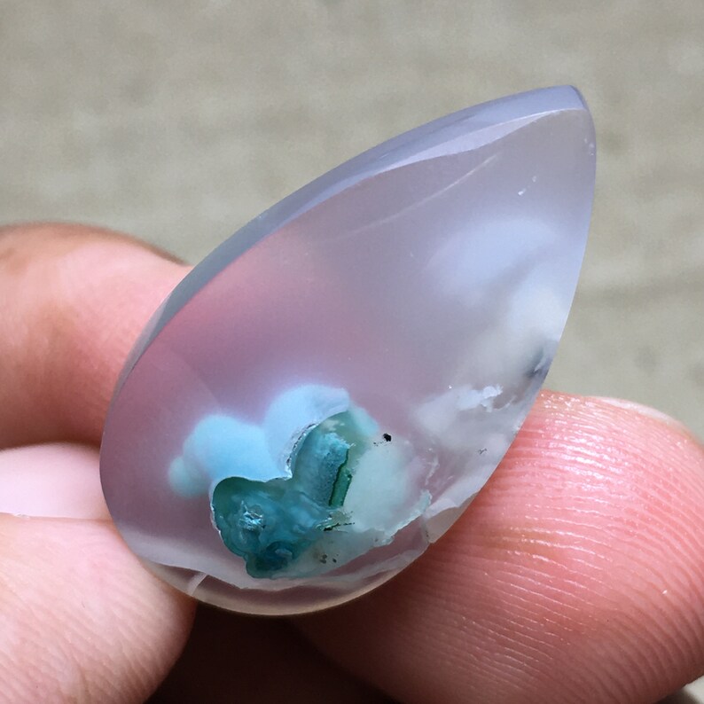 Peut inclure: Un cabochon d'agate translucide en forme de larme, de couleur bleu clair et blanc, avec une inclusion verte et bleue.