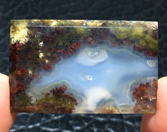 May include: A polished agate stone with a blue, white, and green pattern. The stone has a smooth, polished surface and is a natural gemstone.