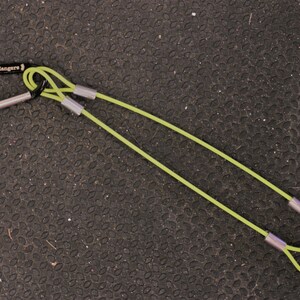 May include: A green exercise strap with a black carabiner clip and silver metal rings. The strap is labeled "WOD Rangers".