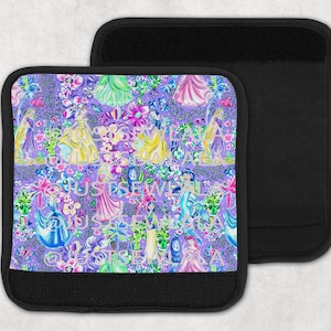 May include: Two black laptop sleeves. One sleeve features a colorful pattern of princesses, flowers, and text on a purple background. The other sleeve is solid black. The pattern includes pink, yellow, blue, and green.