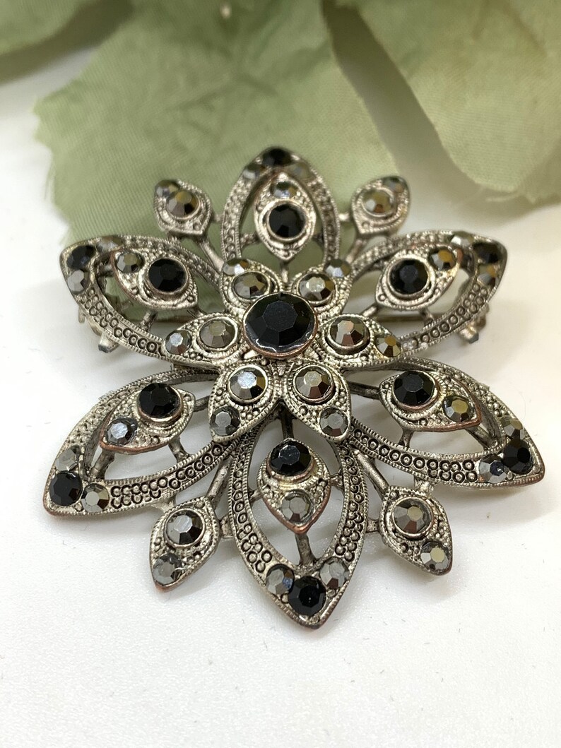 Vintage silver tone and cut iridescent black glass and black rhinestone floral brooch
