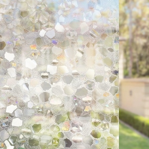 May include: Decorative window film with a textured, irregular pattern. The film features a mosaic of clear and iridescent shapes, creating a shimmering effect. The design allows light to pass through while providing privacy.