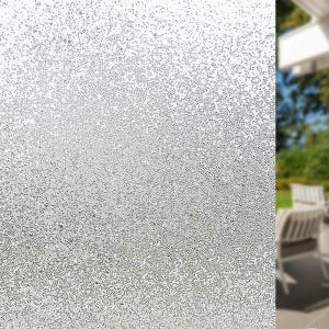 May include: A close-up of a textured, frosted glass panel. The panel is covered in tiny, irregular dots, creating a speckled, semi-opaque appearance. The glass is primarily silver and white, with a slight gradient from top to bottom.