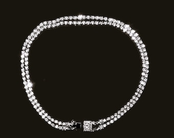 May include: A silver chain necklace with two rows of clear cubic zirconia stones.