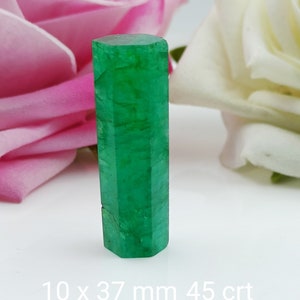 Può includere: Una pietra preziosa smeraldo verde scuro, tagliata a forma di prisma esagonale. Misura 10 x 37 mm e pesa 45 carati.