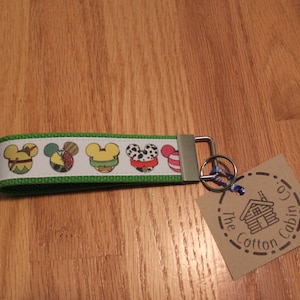 Orejas de Mickey - Varios personajes - Llavero, llavero de pulsera, cinta de grogrén con íconos multicolores, correa de algodón verde con herrajes plateados