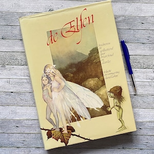 May include: A white ceramic mug with a black handle and the text "But First, Coffee" in a handwritten style. The mug is on a white surface. The mug is likely for hot beverages.