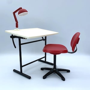 May include: A miniature drafting table with a white rectangular surface and a black metal frame, accompanied by a matching red swivel chair with a black five-point base. A small red adjustable desk lamp is attached to the table surface.