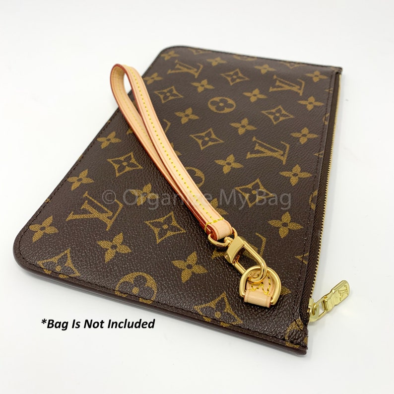 Op de afbeelding: Een bruin en beige leren polsbandje met een gouden rits en een gouden sluiting. Het polsbandje heeft een bruin en beige monogram-patroon. *Tas is niet inbegrepen*