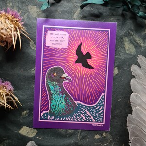 May include: A purple and pink illustrated print with a pigeon and the text "The last sight I ever saw, was the most beautiful." The pigeon is facing left and has a green and blue iridescent sheen. The background is a purple and pink gradient with radiating lines.