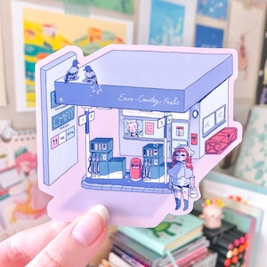 May include: A die-cut sticker featuring a light purple illustration of a petrol station labelled Euro-Country Fuels. The scene includes two pigeons on the roof, fuel pumps, a service window with a clerk, and a person standing in the foreground.