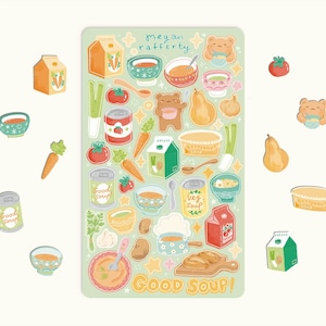 May include: A sticker sheet with a pale green background. It features illustrations of food items such as soup bowls, carrots, tomatoes, and pears. The text "Good Soup!" is at the bottom. The sheet also includes the text "Megan Rafferty".