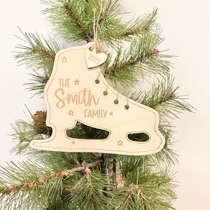 May include: A wooden ice skate ornament with the text "The Smith Family" and a small heart charm with the year "2023" engraved on it.