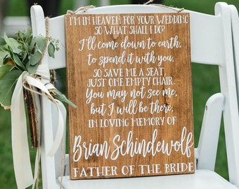 May include: A wooden sign with white text that reads "I'm in heaven for your wedding so what shall I do? I'll come down to earth to spend it with you. So save me a seat, just one empty chair. You may not see me, but I will be there. In loving memory of Brian Schindewolf Father of the Bride."